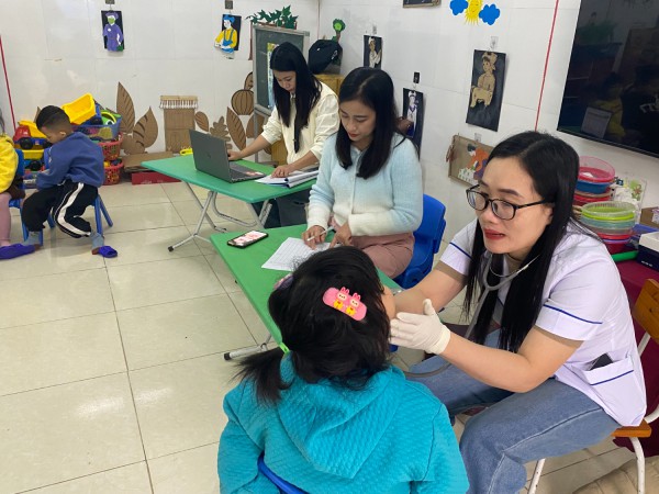 Bác sỹ tại trạm Y tế xã Diễn Phong khám sức khỏe ban đầu cho trẻ